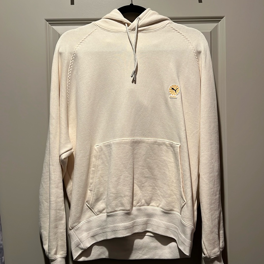 Cream-colored Puma special edition Graphic hoodie with front pocket.